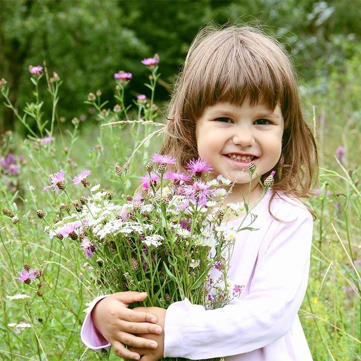 Kind hält einen Strauß Wildblumen